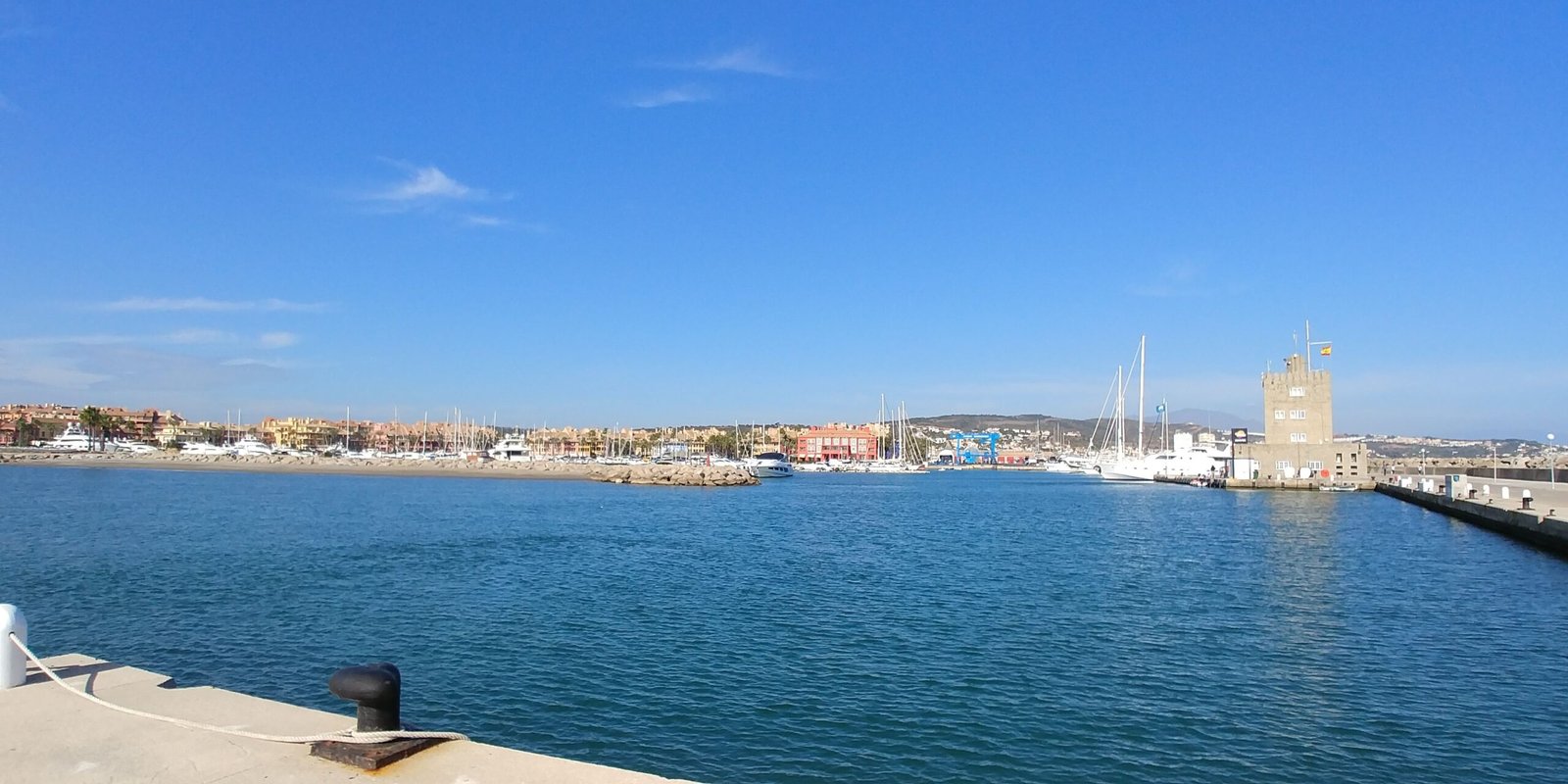 Puerto deportivo con embarcaciones y mar en calma