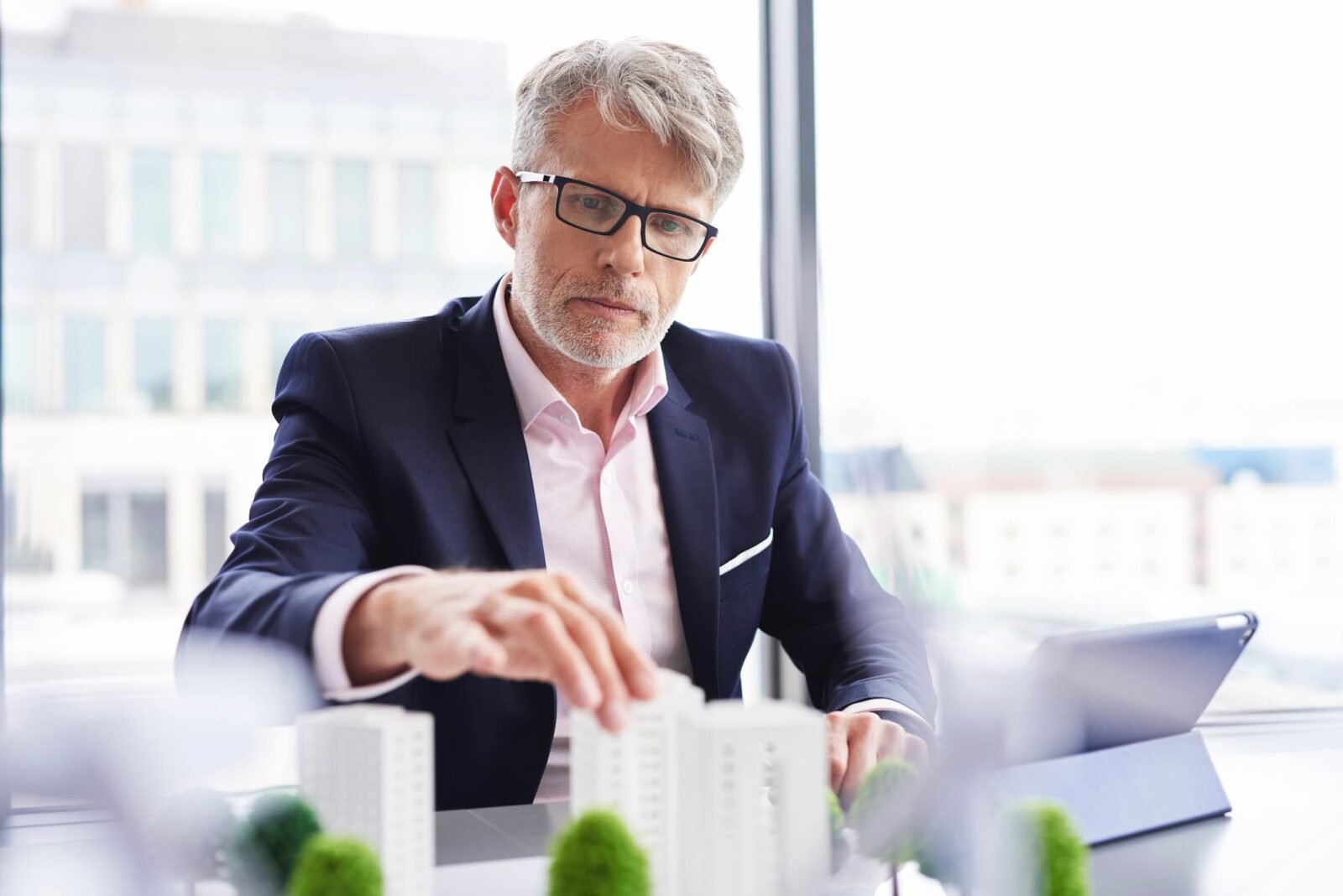Profesional revisando una maqueta de edificios en su despacho